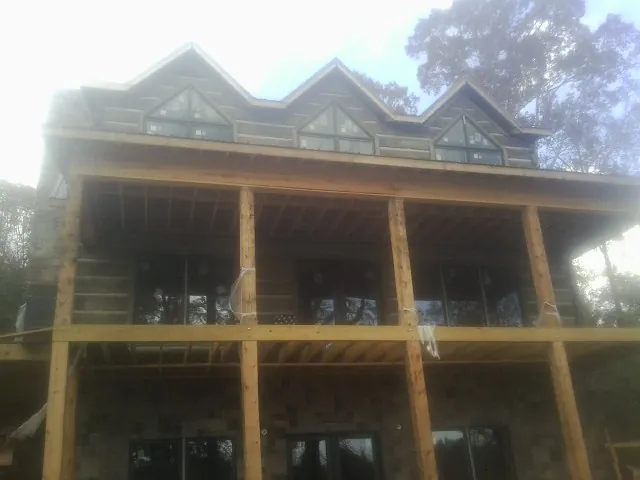 Dormers and porch framing on a large log home under construction — Roof Coating work by our crew in La Jolla